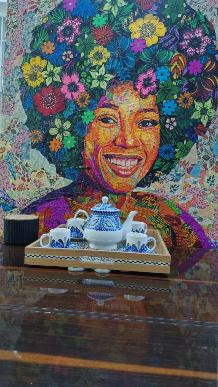 A hand-painted tea service set before a mural in the gallery
