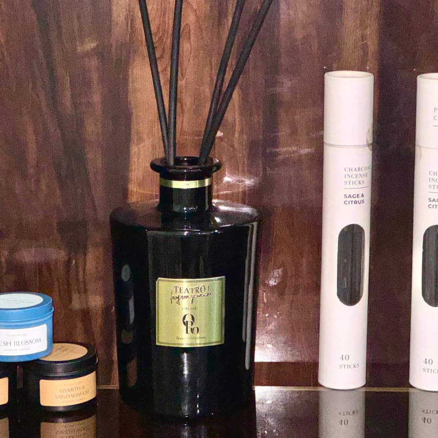 Diffusers and incense on a dark shelf